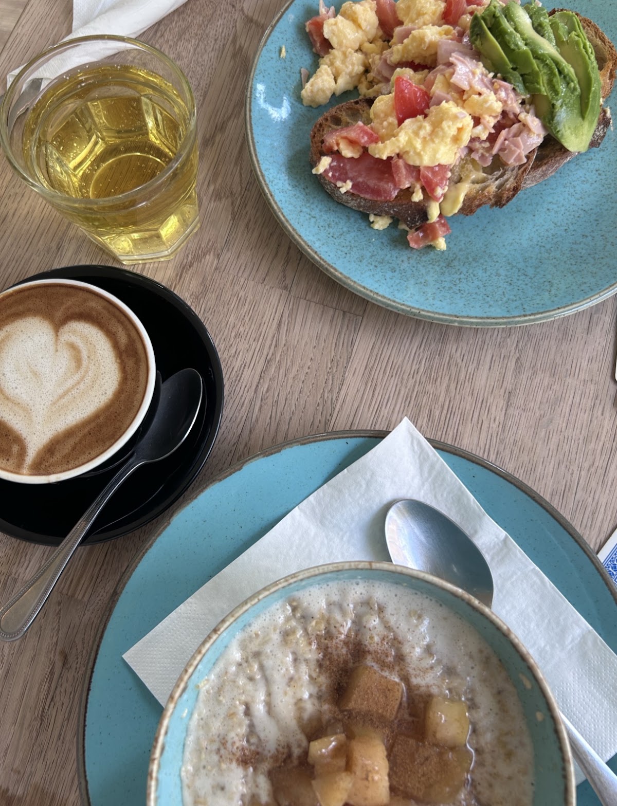 Scrambled eggs with ham, tomato and avocado on sourdough, and porridge with caramelised apple.